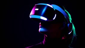 Young woman in VR headset looks around and wonders how amazing. Virtual reality helmet on black background - Powered by Shutterstock - Get 15% off with code: PIKWIZARD15