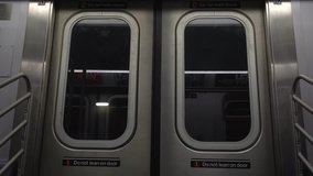 Close up video of a movement and stop of the subway car from inside. An interior view of the doors in the New York City subway. Forbidden sign 