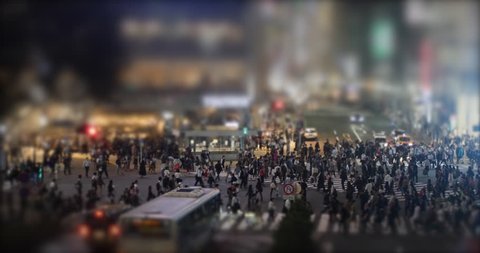 People Walking Crosswalk in Shibuya, Tokyo, Japan. Tilt Shift of crowd crossing. Night view of the most famous shopping district in Japan.