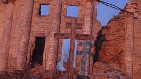 Large wooden cross on the background of a destroyed church. Video full hd.