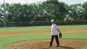 Slow motion of kid pitching ball at baseball park