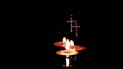 candles and crosses made of precious metal with diamonds on the water surface