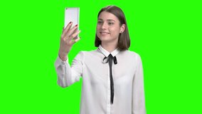 Teenage girl having online video chat using smartphone. Green screen hromakey background for keying.