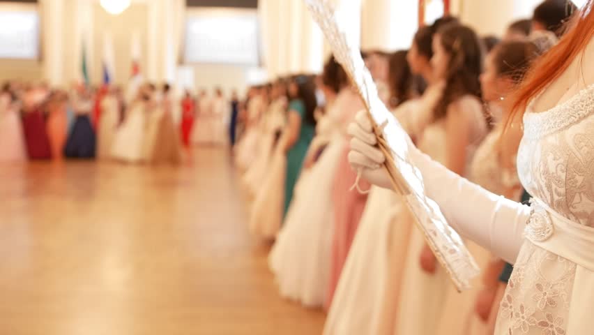 Beautiful woman in vintage ball costume woman waving a fan in the ballroom