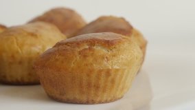 Slow tilt on cornbread baked as a muffin on white plate for breakfast