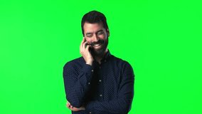 Handsome man with beard talking to mobile on green screen chroma key
