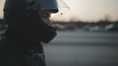 portrait of young attractive motorcyclist with black helmet on street. Man motorcycle biker 
