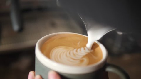 Barista Drawing Latte Art on Coffee with Soy Milk. Process of Making Vegan Lactose Free Drink in Coffeeshop. 4K, Slowmotion Macro Cinematic Closeup.