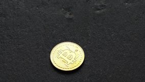 Coins golden bitcoin fall and twist on the graphite surface. Slow motion video. 120 fps.