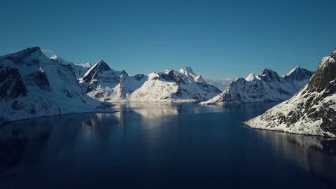 Breathtaking snow covered mountains of Reine, Norway.  Lofoten Islands archipelago in winter.  4k Aerial drone footage