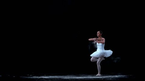 Ballerina performing on black background in super slow motion