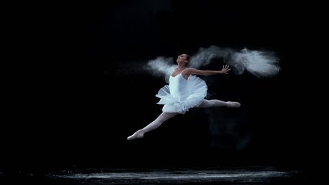 Ballerina performing on black background in super slow motion