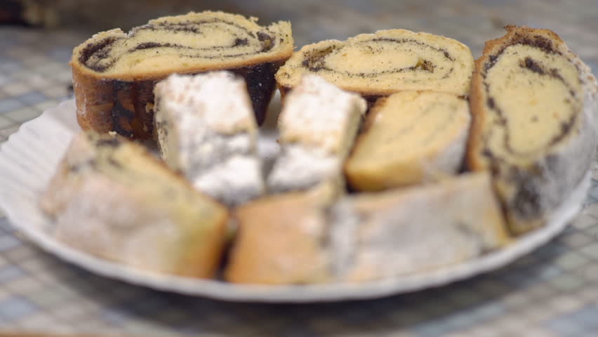 Close-up, Hands of an Elderly Woman Put on a Plate A Slice of Baked Roll with Poppy Filling