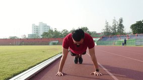 Young asian man doing push ups outdoor in the morning