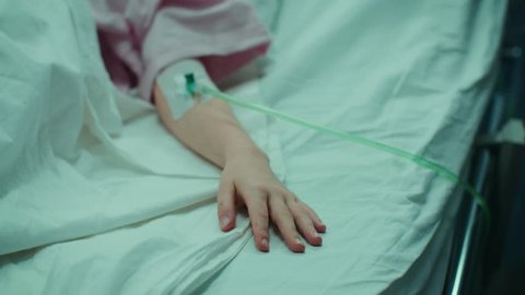 Mother Takes and Holds Hand of Her Sick Little Girl who Is Sleeping in the Hospital Bed. Sad and Hopeful Emotional Moment in Pediatric Ward. Shot on RED EPIC-W 8K Helium Cinema Camera.