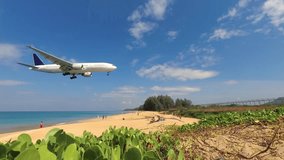 Commercial airliner passes just a few meters over beachgoers. in slow motion. as it lands at Phuket International Airport in Thailand.