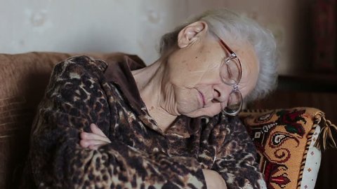 Old woman asleep sitting on the couch