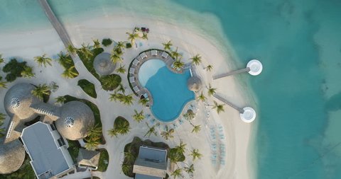 Top Down Aerial View of South Asian Luxury Resort Island. Secluded Paradise Island with Swimming Pool, Living Bungalow's, Palm Trees and Turquoise Sea. Shot in 4K (UHD).