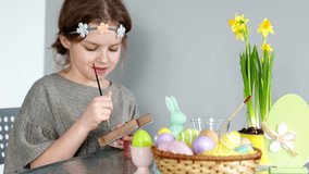 A beautiful girl draws gouache. Happy easter. Preparing for the holiday, children's creativity, Easter bunny, spring flowers
