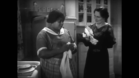 CIRCA 1930s - An African American maid gossips with the woman of the house, in a piece of romance fiction by Beatrice Burton Morgan, in 1935.