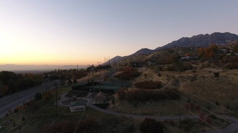 Power lines in the forefront with mountains in the background. Descending into a park. Vídeo Stock