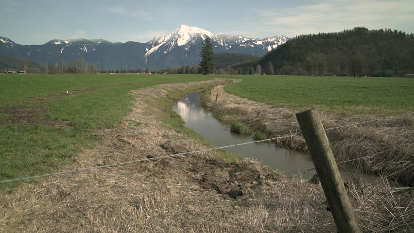 Mount Cheam, Agassiz, BC, zoom 4K UHD. A farm field in the Fraser Valley with Mount Cheam in the background. BC. 4K. UHD.
