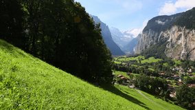 View of alpine fresh green meadows on a great sunny day. Location Lauterbrunnen valley, Staubbach waterfall, Europe. Scenic footage of beautiful nature landscape. Beauty of earth. Full HD 1080p video.