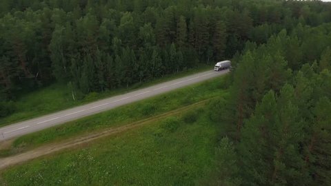 Old truck is driving down the freeway in a wild forest in the Ural Mountains