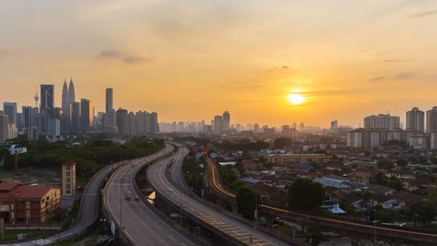 Sunset Time lapse busy of a city skyline with light trail traffic on a freeway of Kuala Lumpur, Malaysia from day to night. Pan to left motion Timelapse.