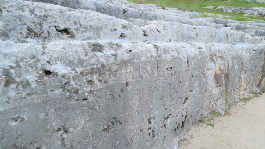The scriptures on the wall of the greek theatre in Neapolis in Italy seen on a closer look the writings on the ruins in Sicily