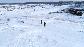 Snowboarder riding down the slope on a snowy field, 4k video clip. Aerial shot of snowboarding