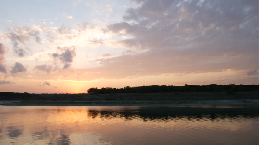 Time Lapse of Sunset Behind Small Hill Reflecting on the Water