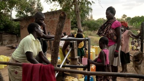 UGANDA, GULU - 15 February 2017: African children filling up a plastic container at a water well in Rural Uganda, Africa