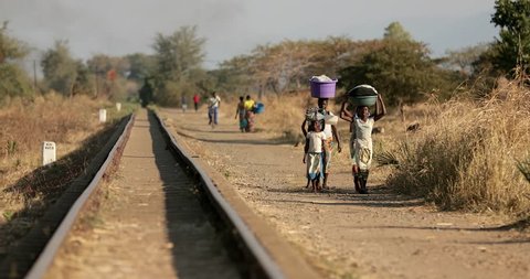 Mzuzu, Malawi,  July 16 2017: is a city in northern Malawi. It’s a gateway to Lake Malawi and the fishing village of Nkhata Bay, both to the east. To the south. People walk along the tracks.