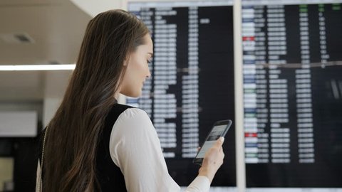 Travel woman using smartphone at airport. Young caucasian traveler checking boarding time with mobile phone app in terminal or train station. Business woman businesswoman Tourist on vacation