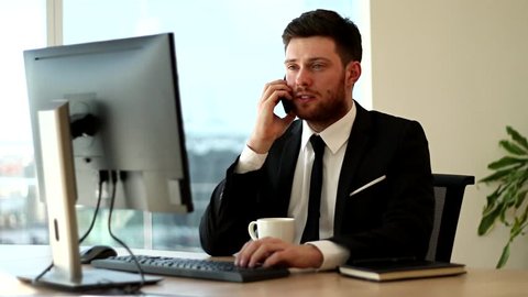 Businessman talking on the phone. Typing while talking on the phone