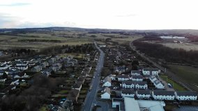 Aerial drone footage of suburban houses and fields in the evening Spring. 