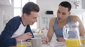 Handheld shot of young male couple doing a crossword at breakfast one morning - Powered by Shutterstock - Get 15% off with code: PIKWIZARD15
