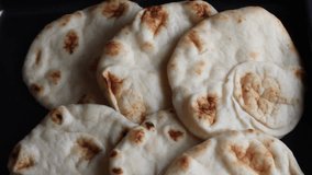 Naan breads freshly baked and laid over a surface. Tiltdown video in HD.