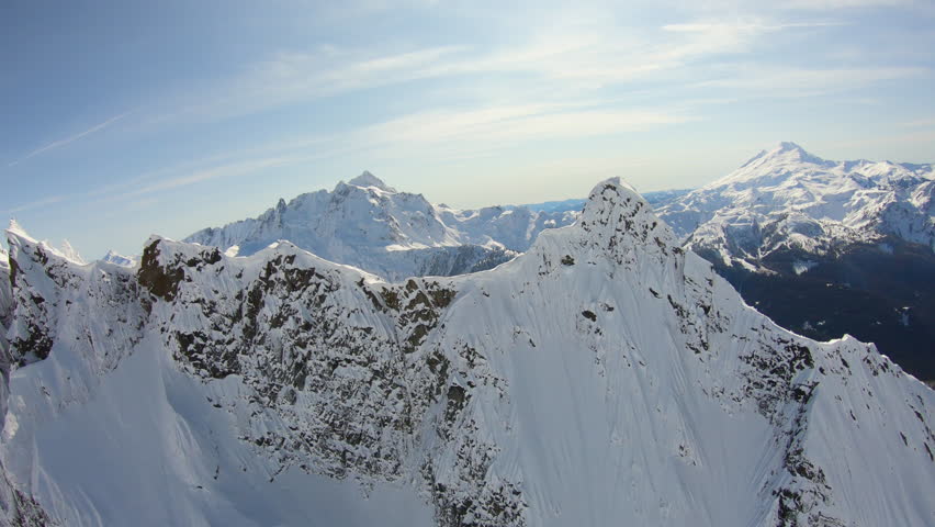 Triangle Shaped Steep Rocky Peak Aerial Flyby Close Up Snowy North Cascade Mountains Looking at Mt Shuksan and Mount Baker Nature Winter Reveal Behind North Cascade Mountains