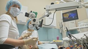 Doctor used special Dental Intraoral Check Digital Micro Camera to exam teeth. On the monitor dentist and patient see video of teeth, tooth problems. Orthodontist used microscope. Dentist is treating
