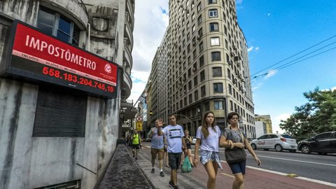 Sao Paulo, Brazil, March 24, 2018. Impostometro (panel with taxes paid in the country) and people walk on Boa Vista Street in downtown Sao Paulo, Brazil