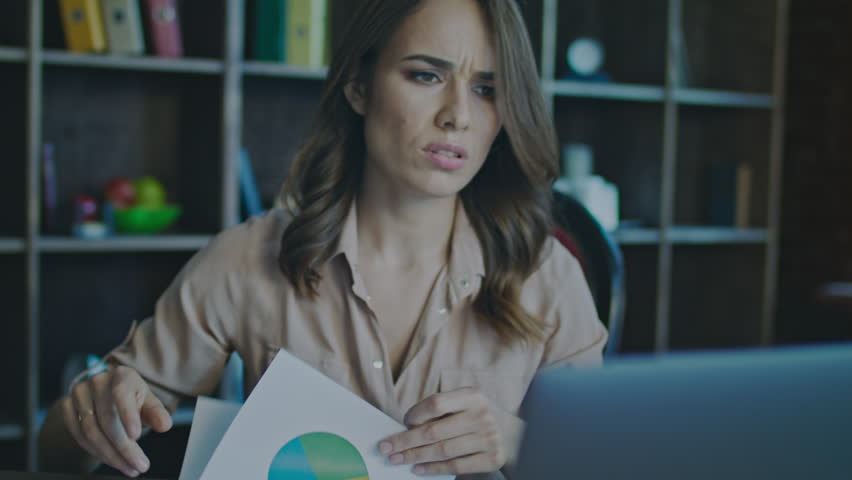 Upset business woman working on laptop in office. Portrait of unhappy woman working with documents. Close up of worried businesswoman face looking monitor. DIssapointed manager working with papers | Shutterstock HD Video #1009417922