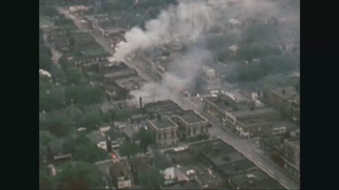 CIRCA 1967 - Aerial views of a burning block of buildings and destroyed homes during the Detroit Riots.