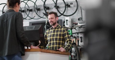 Small business owner serving customer in a bicycle store Arkivvideo