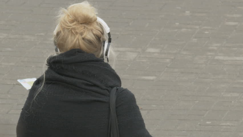 Young Woman Standing and Listening to Music in the Street