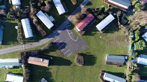 Aerial top down view of campsite or camping pitch place used for overnight stay in outdoor area showing the places divided into pitches where people can camp overnight using camper vans or caravans 4k
