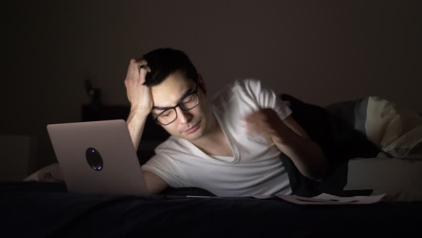 Working late at night in bed with a laptop.