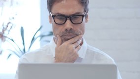 Pensive Middle Aged Man Thinking and Working on Laptop, Front Close Up - Powered by Shutterstock - Get 15% off with code: PIKWIZARD15