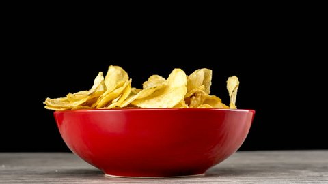 Bowl filled with potato chips being eaten: stockvideo